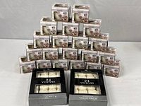 Stack of boxed Luminessence candles with two Dynamic Collections 24-packs