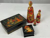 Group view of all items: three nesting dolls, rectangular lacquer box, square lacquer box