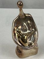 front view of abstract silverplate mother and child sculpture