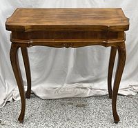 Front view of folded wood game table with cabriole legs
