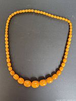Full view of graduated orange Bakelite bead necklace