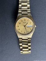 Full view of Bulova gold-tone wristwatch on dark background