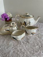 Complete tea set showing teapot, sugar bowl, creamer, covered butter dish