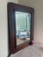 Full view of oak framed mirror leaning against wall