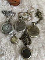 All six pocket watches closed showing case designs and chains