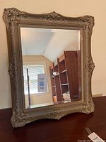 Full view of ornate framed mirror on surface