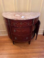 Front view of demi-lune cabinet showing marble top and marquetry front