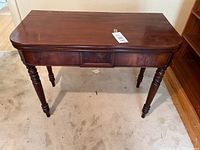 Front view of mahogany games table showing overall form and finish