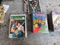 Stacked bagged comics showing Deathstroke the Terminator and The Demon issues