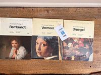 All three art books side by side showing covers