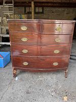 Full view of bow-front chest showing five drawers and brass hardware