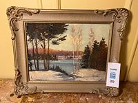 Framed winter landscape painting with frame visible