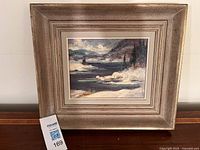 Full view of framed painting on stand with lot tag visible
