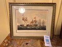 Framed nautical print showing warships at sea under glass