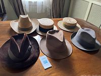 Six hats arranged on table showing variety