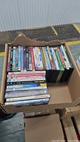 Box of DVDs showing variety of titles and case conditions