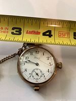 Front view of Tavannes pocket watch showing dial, crystal crack and tape measure for diameter reference