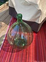 Full view of green glass carboy jug standing upright