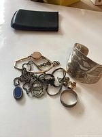 Overall view of jewellery lot including cuff, rings, pendants, watch chain and earrings
