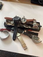 Pile of assorted wristwatches showing variety and quantity