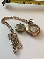 Both watches and chain with measuring tape for scale