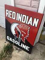 Front view of Red Indian Gasoline sign showing text, logo and color scheme