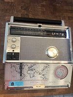 Front view showing tuning dial, knobs, and fold-out world map panel