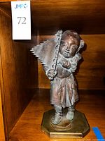 Front view of bronze figure holding flag on brass plinth