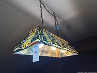 Overall view of stained glass billiard light illuminated