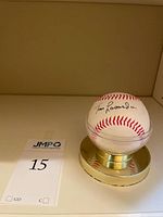 Signed baseball on gold-tone base with lot tag visible