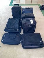 Front view showing six of the luggage pieces including two upright suitcases, two garment bags and one brief bag