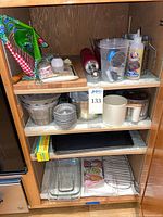 Cabinet with full lot: molds, flour sifter, rolling pin, measuring cups, baking sheets, dishes