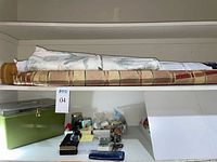 Shelf with rolled fabrics and green tool case