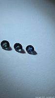 Three round blue sapphires on white background