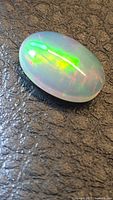 Oval cabochon opal showing multicolor flash