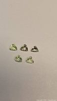 Five yellow-green trillion-cut gemstones frontal view