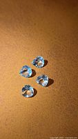 Four pear cut blue topaz gems on brown background