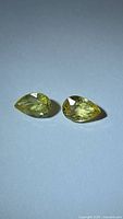 Front view of both yellow sapphires showing pear shape and color