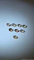 Eight oval faceted champagne tanzanite stones on white background
