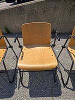 Front view of one chair showing plywood seat, back, armrests and sled base