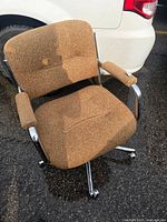 Front angled view of chair showing upholstery, arms and chrome frame