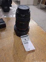 Lens standing vertically with hood and front cap