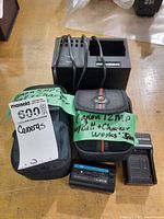 Lot overview showing two Canon camera cases, multi-slot charger, Sony battery and charger