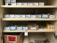 Cabinet shelf with multiple Spaenaur boxes, washer spool and misc boxes