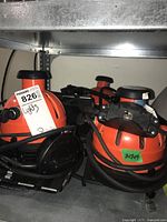 Two orange Ianiro VariBeam spot lights with coiled power cords visible on shelf