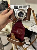 Front view of Kodak Retinette IB camera in open brown leather case showing lens and body