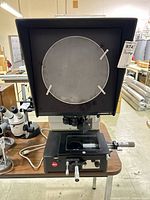 Front view of optical comparator showing projection screen, XY stage and Leica badge