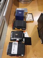 Overview of lens, roll film backs, and accessory boxes on table