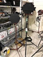 Two lights on rolling stands with barndoors closed