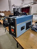 Left side view showing blue body, eyepiece lens, carry handle, modification label